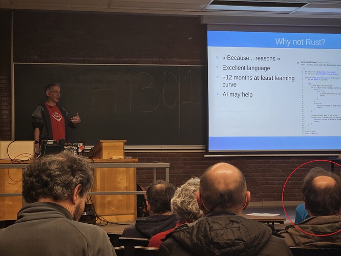 FOSDEM 발표장과 맨 앞 자리에 앉아 있는 Devroom 관리자의 모습.